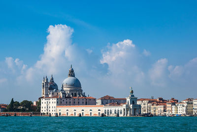 Grand canal with santa maria della salute in background against blue sky