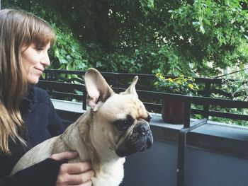 Close-up of woman with french bulldog in balcony