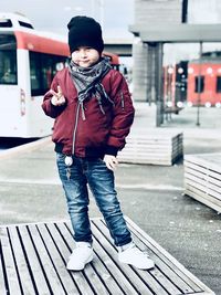 Full length portrait of boy showing peace sign