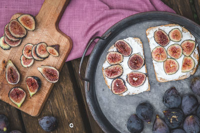 Top view of soft ricotta sandwich with ripe figs served on a tray.