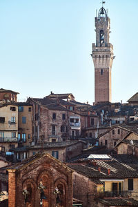Buildings in city against clear sky