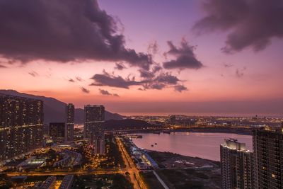 High angle view of illuminated cityscape against sky at dusk