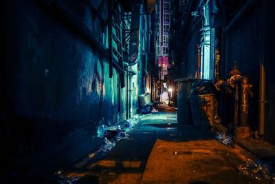 Alley amidst buildings in city at night