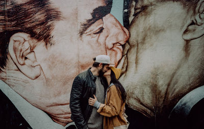 Couple kissing against wallpaper