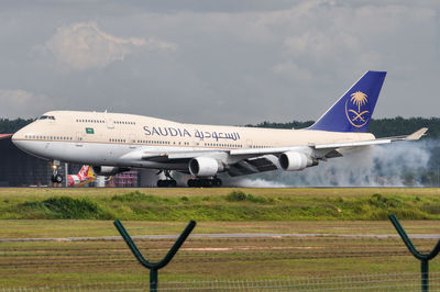 Airplane on airport runway against sky