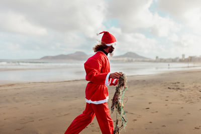 Full length of man standing on beach against sky