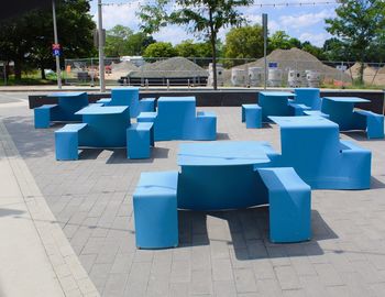 Empty chairs and tables in row against blue wall