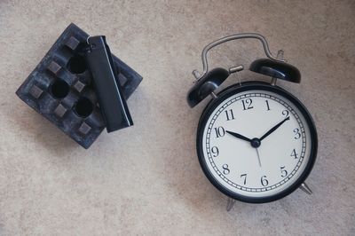 Close-up of alarm clock and ashtray on the table