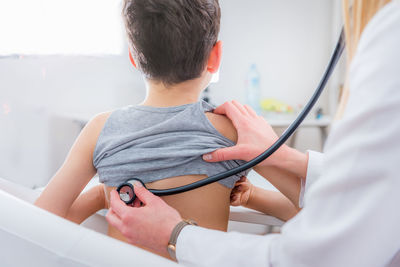 Female doctor examining boy at clinic