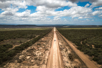 A car on a dirt road leading to the addo elephant national park, near port elizabeth from a drone