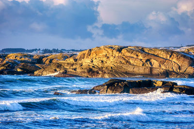 Scenic view of sea and rock formation against sky