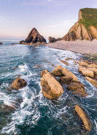 Scenic view of rocks in sea against sky