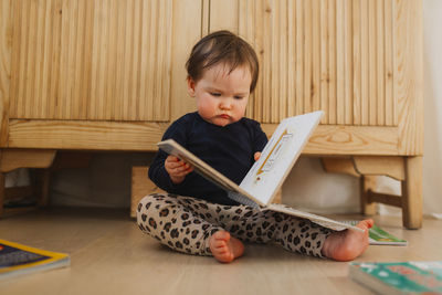 Toddler girl reading book