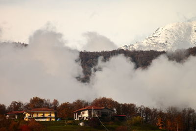 Autumn mood in a mountain village between mist and snow