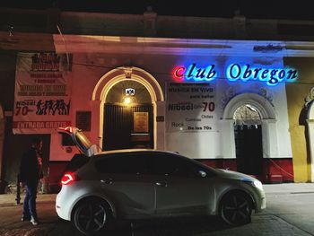 Car on illuminated building at night