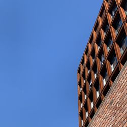 Low angle view of modern building against clear blue sky