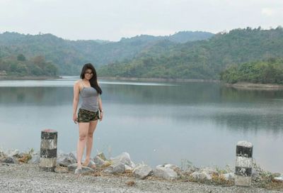 Portrait of woman standing on lake