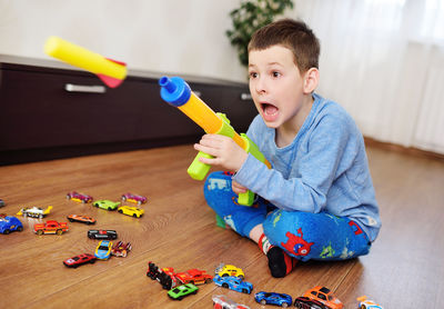 A foam bullet or rocket flies out of a toy machine gun.