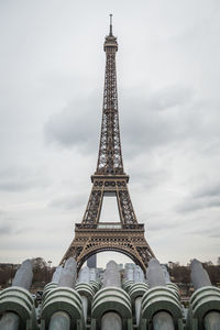 The eiffel tower from the water cannons of the trocadero square in paris under a stormy gray sky