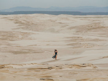 Rear view of man walking at beach