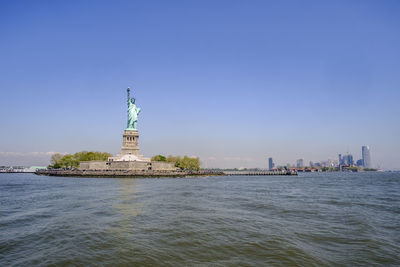 Statue of liberty against sky in city