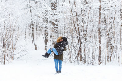 Full length of woman standing on snow covered field