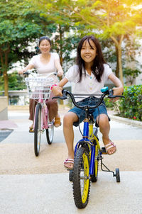 Woman and girl cycling at park