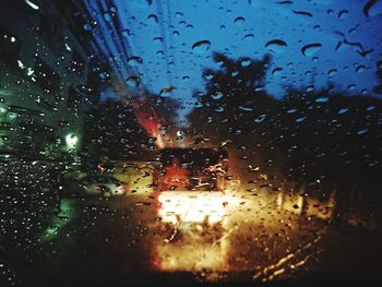 Cars on road seen through wet window during rainy season