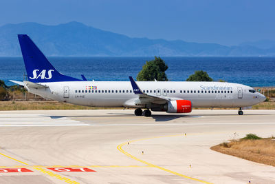 View of airplane at airport runway against sky