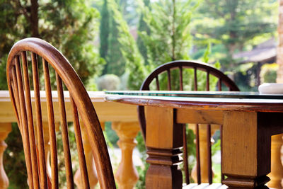 Close-up of vase on table by chair at balcony