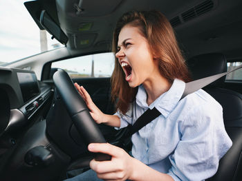 Portrait of young woman sitting in car