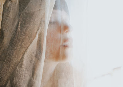 Close-up of woman covered in textile at home