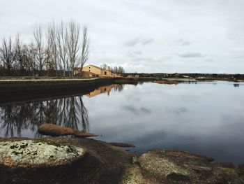 Scenic view of calm lake against cloudy sky