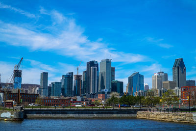 City at waterfront against blue sky