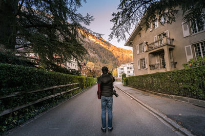 Rear view of man standing on road in city