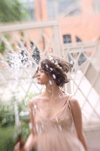 Girl holding garden hose while standing outdoors