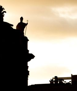 Low angle view of silhouette statue against sky during sunset