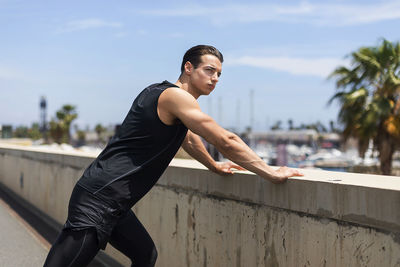 Confident young man exercising during sunny day