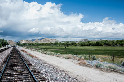 Railroad track against cloudy sky