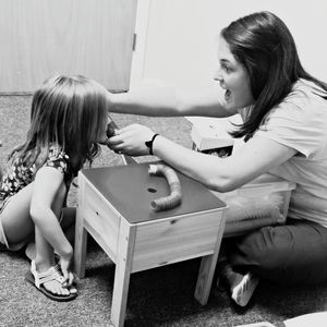 Mother teaching daughter speech therapy at home