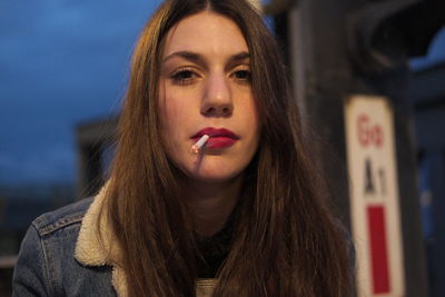 Close-up portrait of young woman smoking