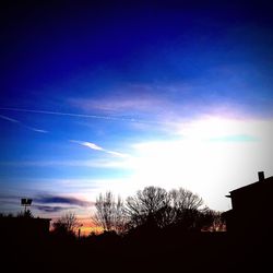 Silhouette of trees against cloudy sky