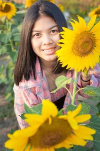 Portrait of smiling woman holding yellow flower