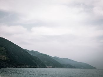 Scenic view of sea and mountains against sky