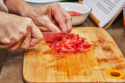 Cropped hand of person preparing food on cutting board