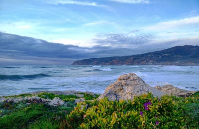 Scenic view of sea and mountains against sky