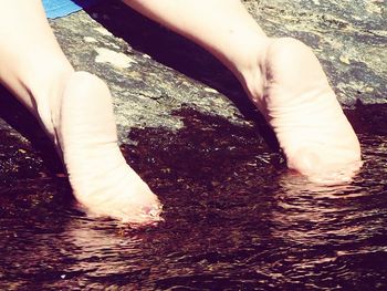 Low section of woman standing in water