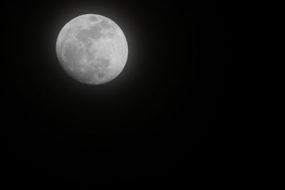 Low angle view of full moon against clear sky at night