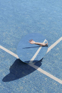 High angle view of man hand seen in mirror on tennis court