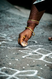 Indian woman drawing rangoli on the occasion of eve